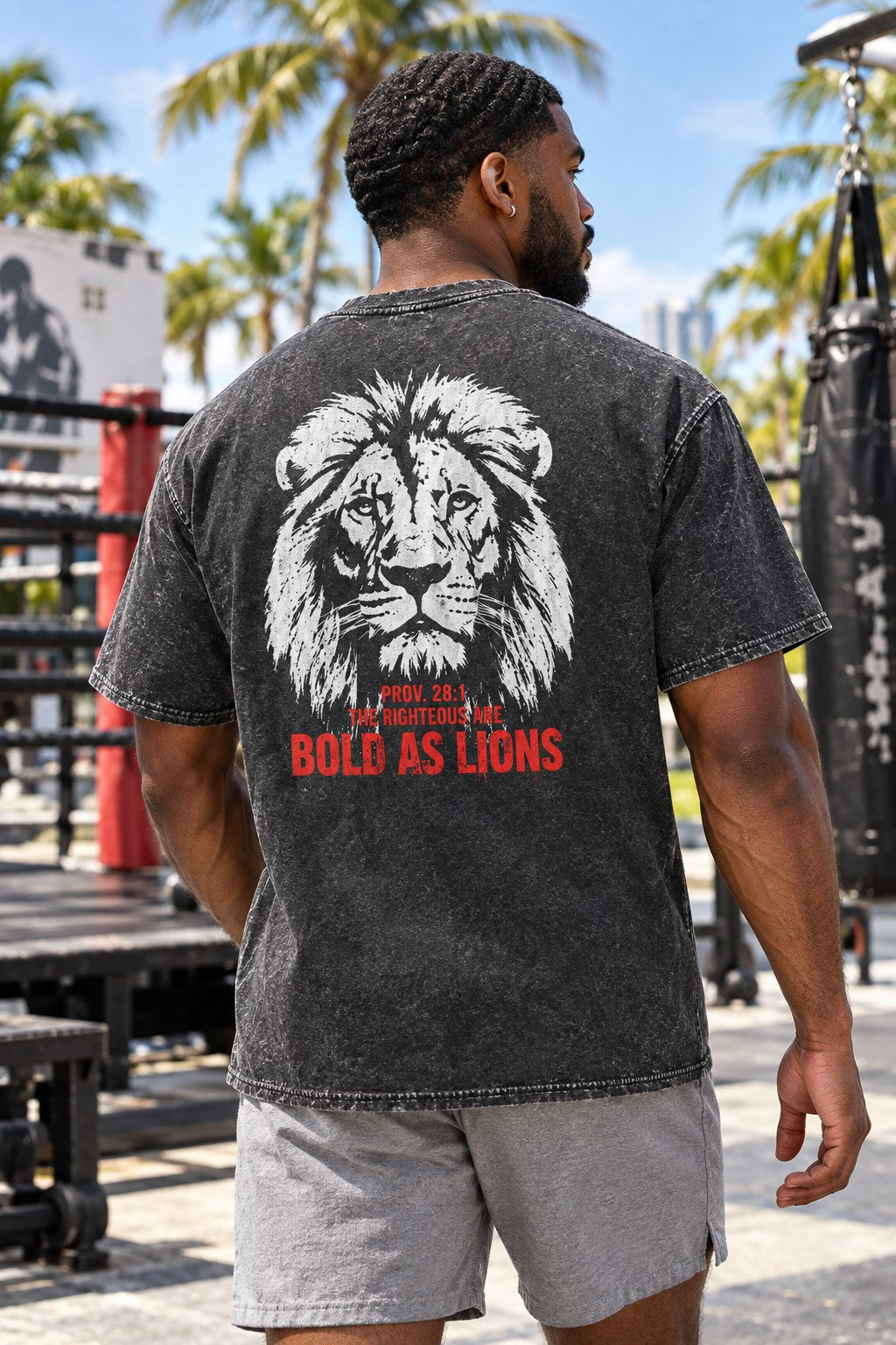 Man wearing acid wash Bold as Lions Proverbs 28:1 tee at an outdoor Miami boxing gym, back