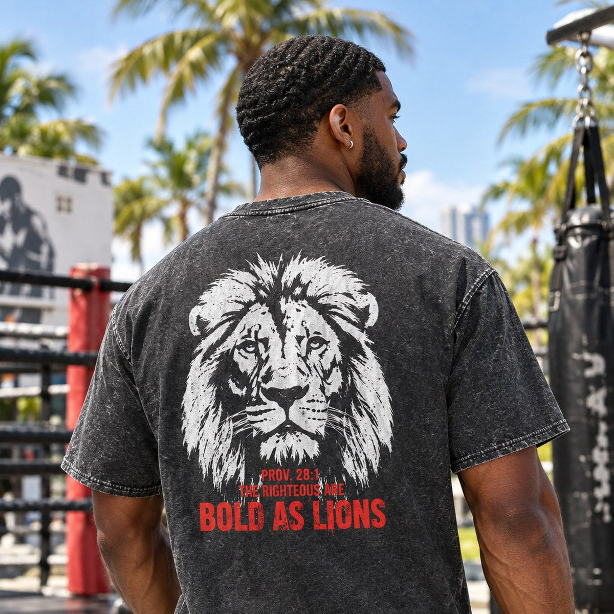 Man wearing acid wash Bold as Lions Proverbs 28:1 tee at an outdoor Miami boxing gym, back graphic view